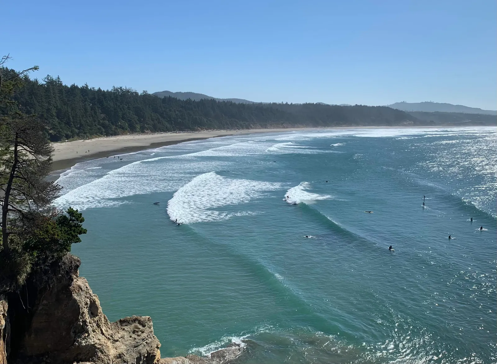 Surfers in the gentle waves at Otter Rock Beach, Oregon