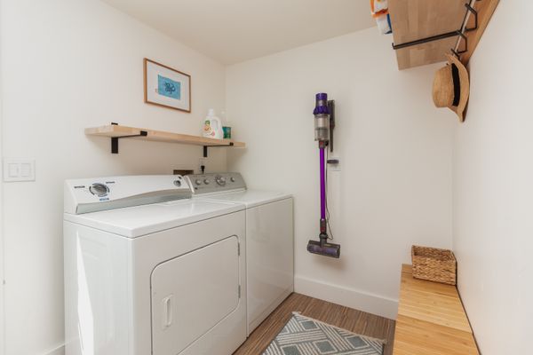 Mudroom with washer, dryer, hooks, and vacuum