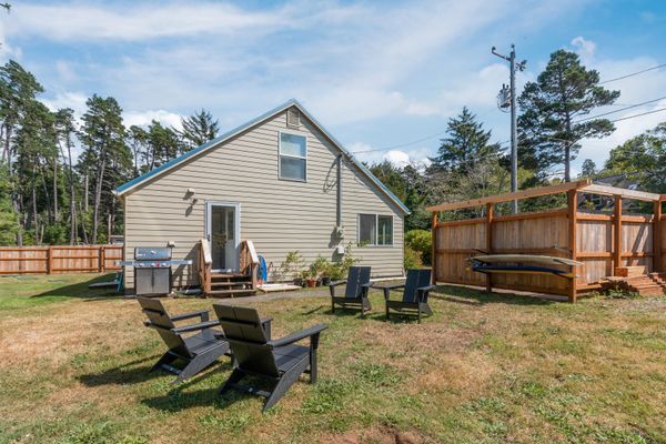 Backyard with gas grill, Adirondack chairs, and cedar surfboard rack